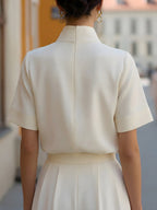 Elegante Damenbluse mit hohem Stehkragen, kurzen Ärmeln und minimalistischer, taillierter Passform für Büro und smart-casual Anlässe
