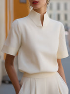 Elegante Damenbluse mit hohem Stehkragen, kurzen Ärmeln und minimalistischer, taillierter Passform für Büro und smart-casual Anlässe